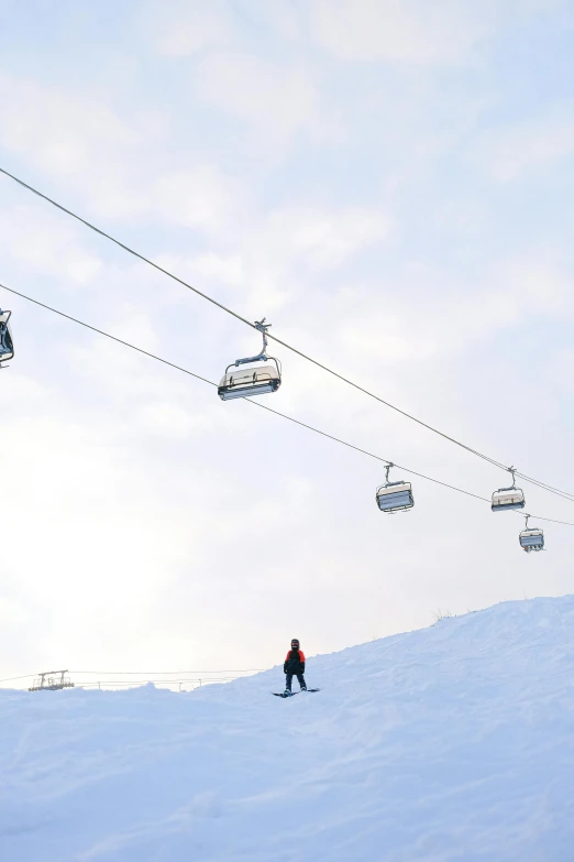 a man riding a snowboard down a snow covered slope, trams ) ) ), chairlifts, instagram picture, scandinavian