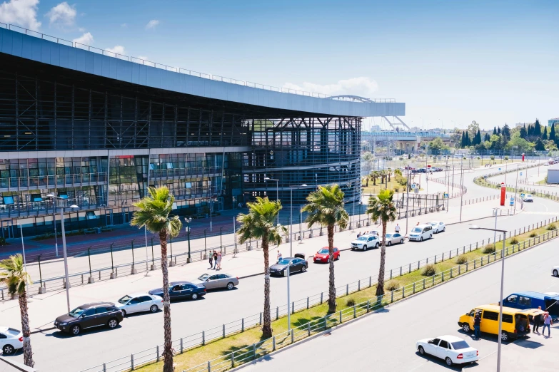 a parking lot filled with lots of cars next to a tall building, by Hugo Sánchez Bonilla, pexels contest winner, hurufiyya, baseball stadium, jerez, train station in summer, in a beachfront environment