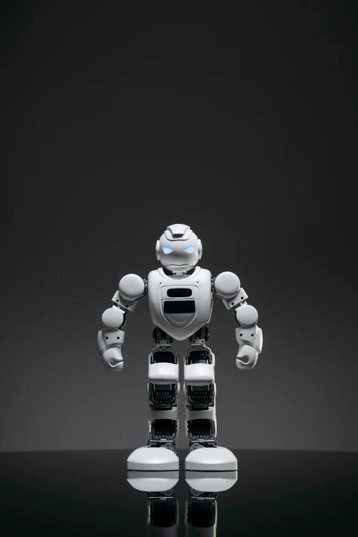 a close up of a toy robot on a table, in front of a black background, < full body robot >, pepper, average