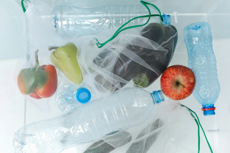 a plastic bag filled with assorted fruits and vegetables, a still life, unsplash, plasticien, water bottles, portrait image