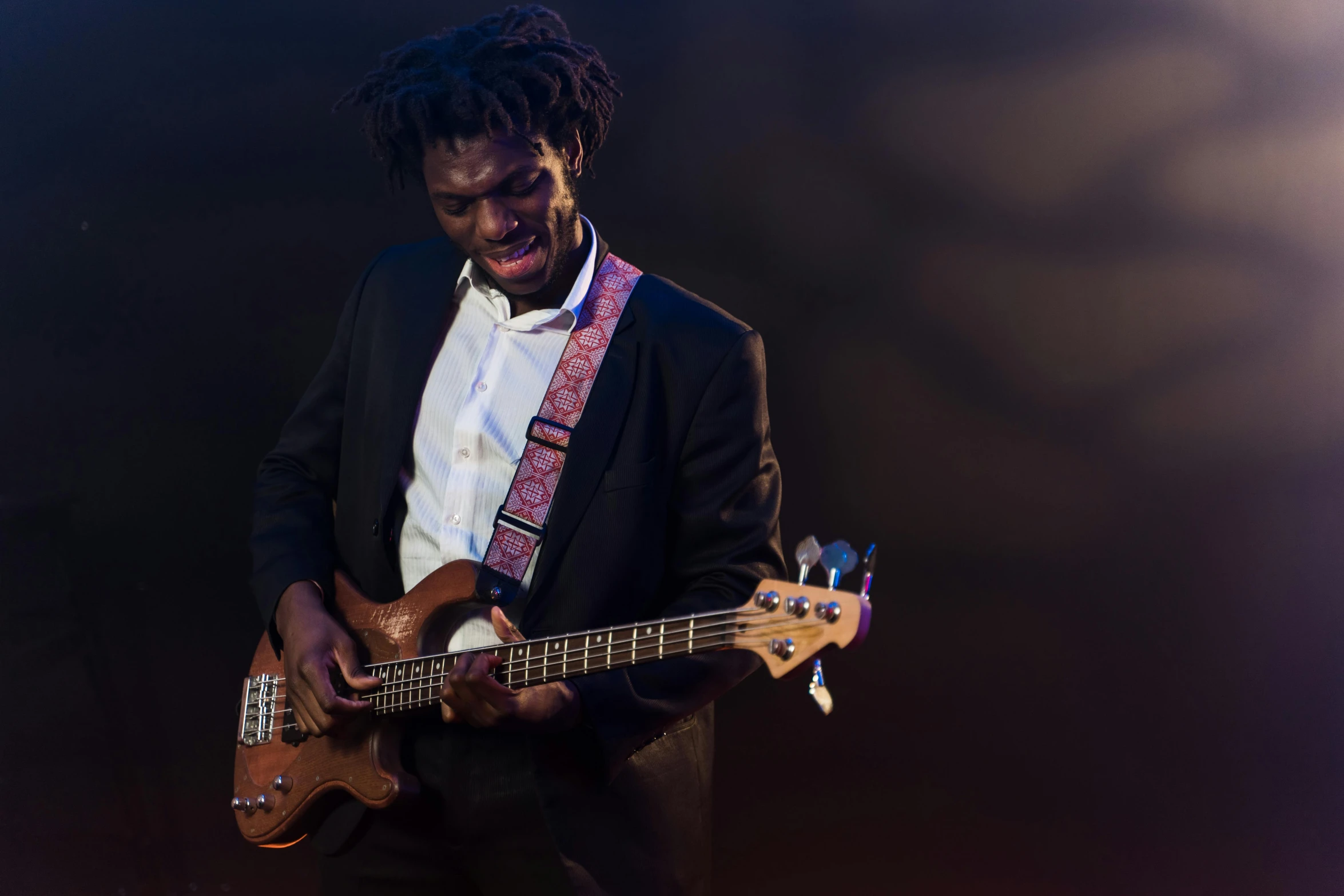 a man in a suit playing a guitar, pexels contest winner, man is with black skin, bassist, lachlan bailey, riyahd cassiem