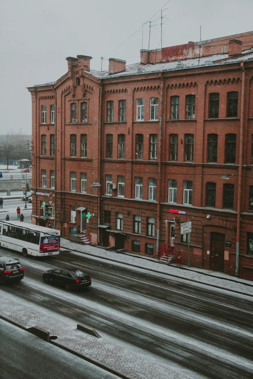 a street filled with lots of traffic next to tall buildings, a photo, inspired by Vasily Surikov, pexels contest winner, snow outside the windows, red bricks, saint petersburg, school