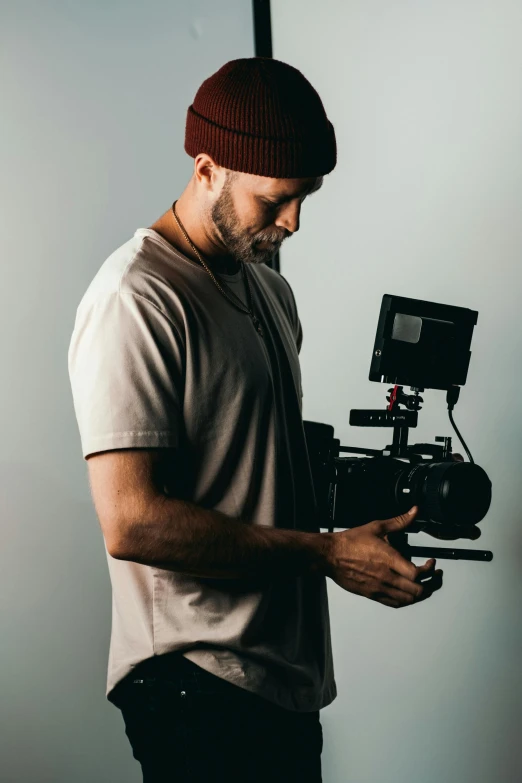 a man standing in front of a camera, holding a camera