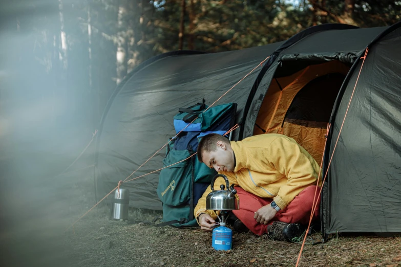 a little boy that is sitting in front of a tent, by Julia Pishtar, pexels contest winner, cooking it up, avatar image, a man wearing a backpack, boiling