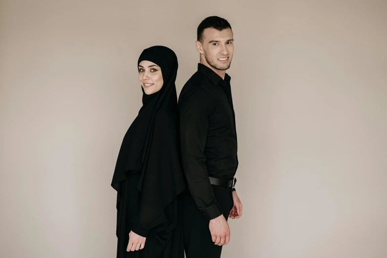 a man and a woman standing next to each other, hurufiyya, wearing black clothes, official product photo, profile image, middle eastern skin