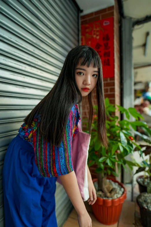 a woman standing next to a bunch of potted plants, an album cover, by helen huang, pexels contest winner, red and blue garments, portrait of a japanese teen, colorful pigtail, cinematic. by leng jun