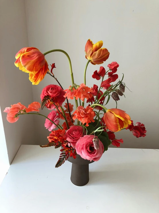 a vase filled with lots of different colored flowers, by Jessie Algie, light red and deep orange mood, red neon details, tulip, medium wide front shot