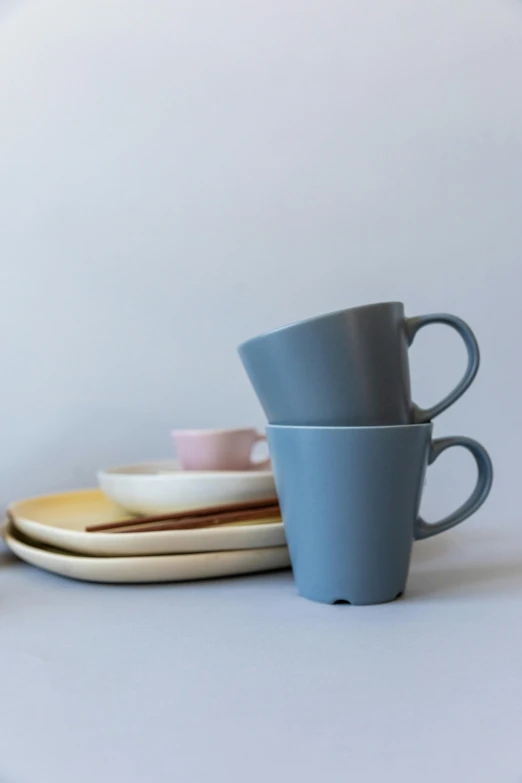 a couple of cups sitting on top of a table, inspired by Gao Cen, unsplash, solid colours material, square, close-up product photo, gray