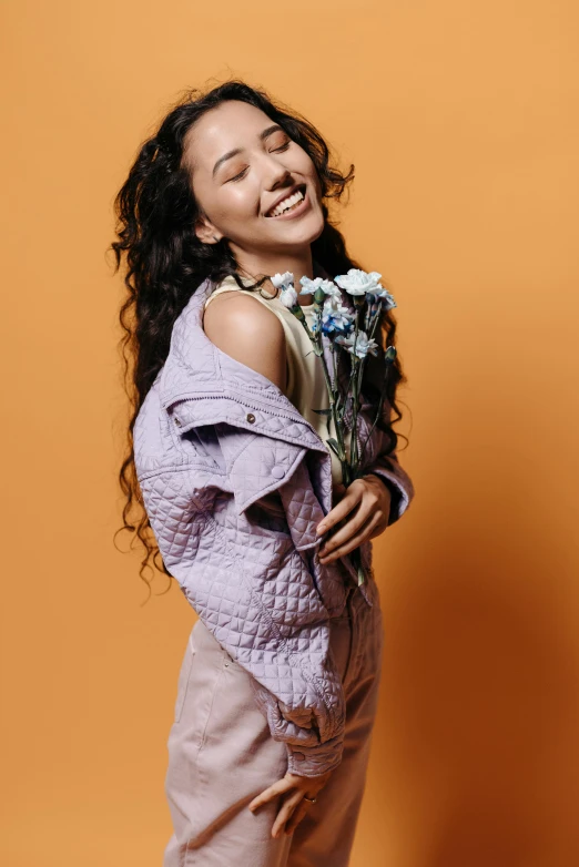 a beautiful young woman holding a bunch of flowers, trending on pexels, antipodeans, orange jacket, zendaya, purple leather garments, wavy hair spread out