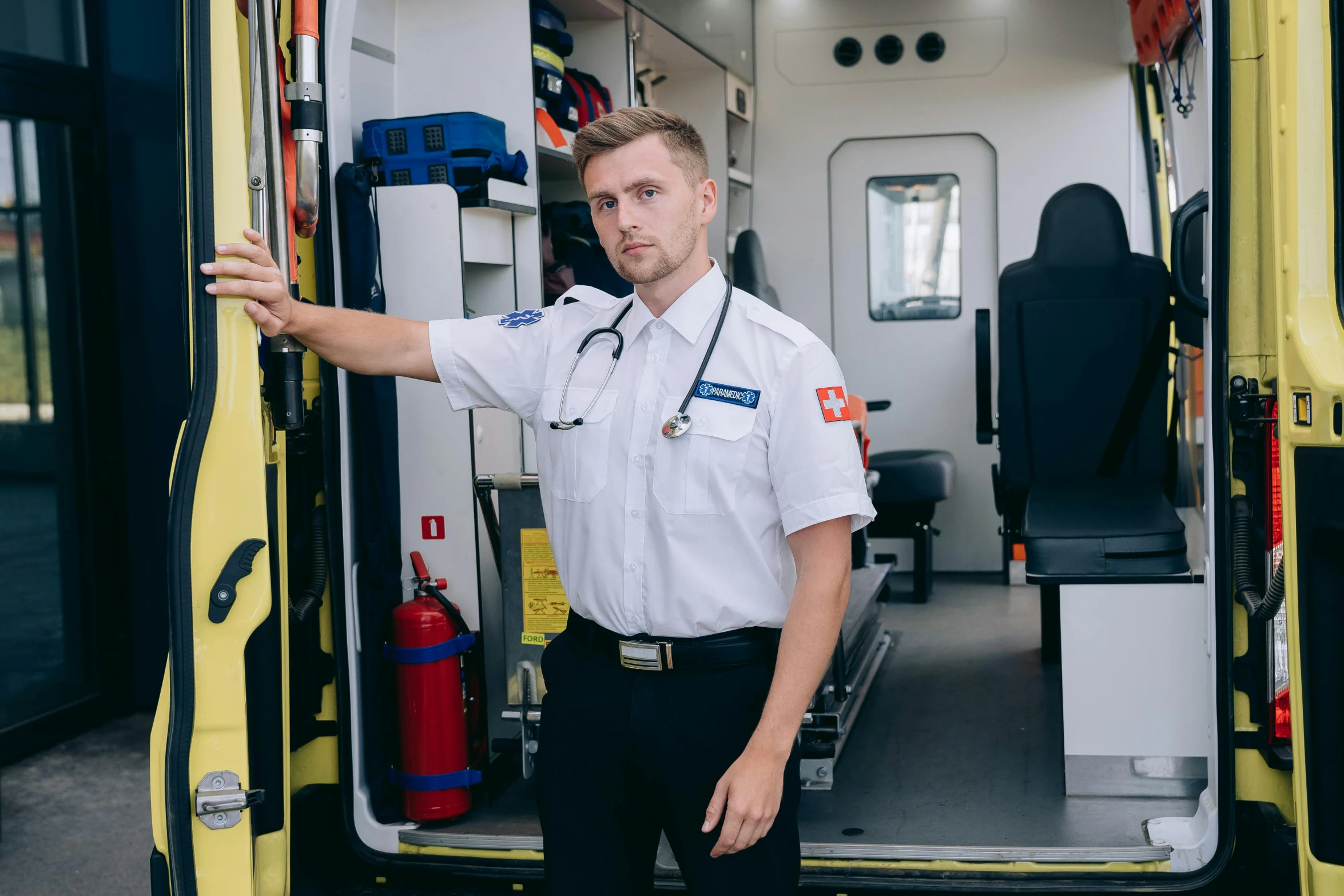 a man standing in the doorway of an ambulance, a portrait, by Adam Marczyński, pexels contest winner, uniform, avatar image, high quality image, rectangle