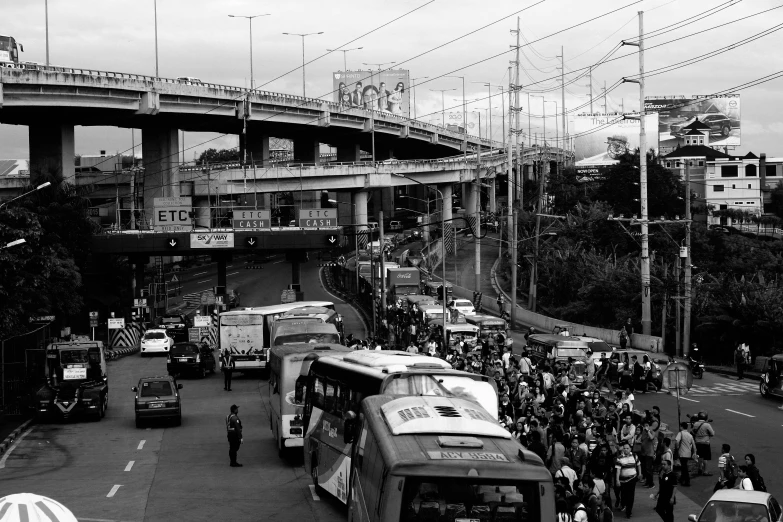 a black and white photo of a busy city street, by Alejandro Obregón, philippines, overpass, bus, stuck