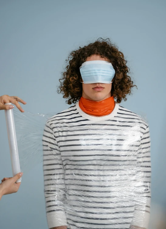 a woman with a blindfold covering her eyes, an album cover, by Ryan Pancoast, trending on reddit, plasticien, plastic wrap, wearing stripe shirt, stable diffusion ai as a human, wearing turtleneck