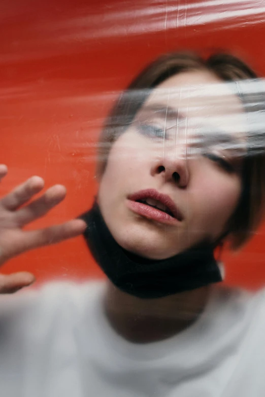 a woman holding a pair of scissors in front of her face, a picture, inspired by Anna Füssli, trending on pexels, surrealism, blurry footage, person made out of glass, synesthesia, in a spaceship