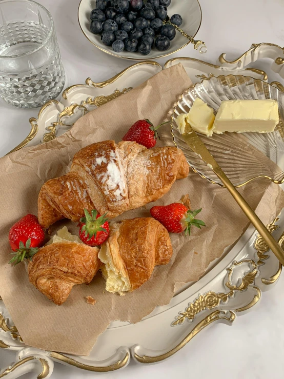 a close up of a plate of food on a table, by Lucette Barker, rococo, butter, dynamic angled shot, pastries, shiny silver