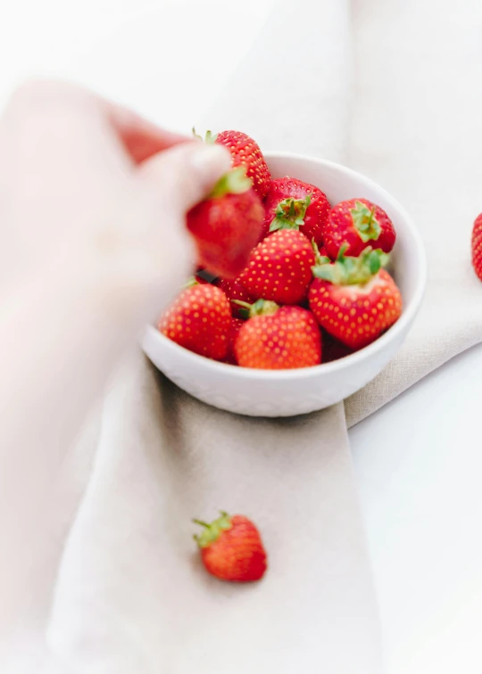 a bowl of strawberries sitting on top of a table, profile image, partially cupping her hands, high quality product image”