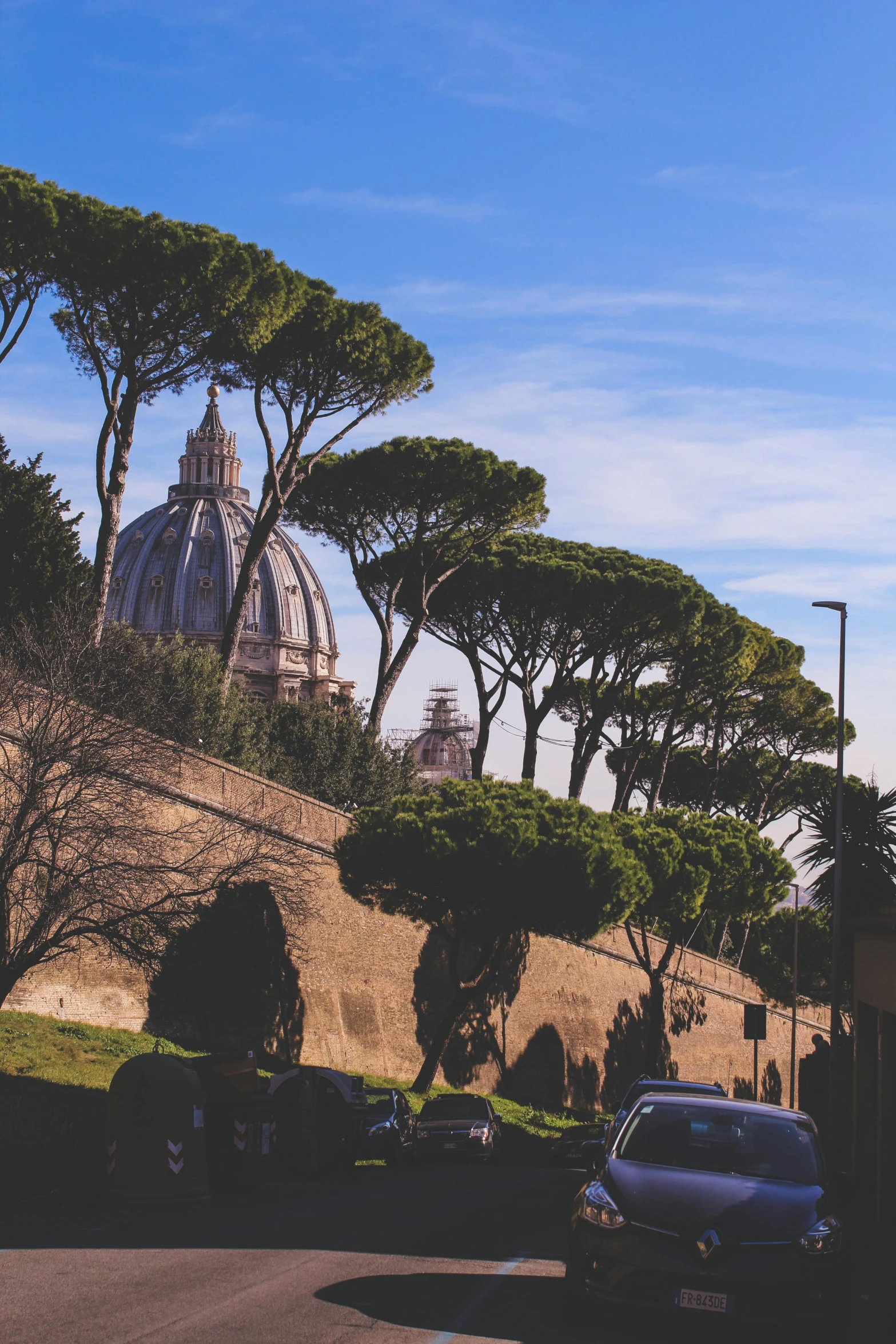 a car is parked on the side of the road, by Cagnaccio di San Pietro, pexels contest winner, neoclassicism, domes, hill with trees, 🚿🗝📝