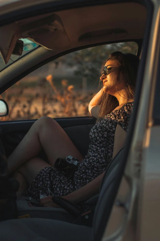 a woman sitting in a car talking on a cell phone, a picture, inspired by Elsa Bleda, pexels contest winner, renaissance, wearing a sun dress, seducing, wearing dirty travelling clothes, low sun