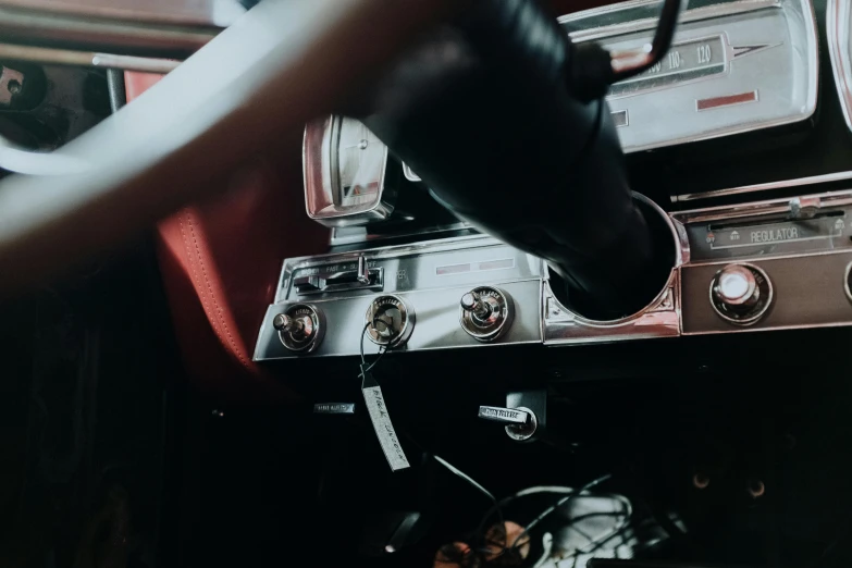 a close up of a dashboard of a car, an album cover, trending on pexels, in classic diner, levers, holding controller, silver details