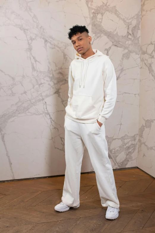 a man standing in front of a marble wall, inspired by Louis Hersent, wearing a hoodie and sweatpants, off - white collection, detailed product image, small