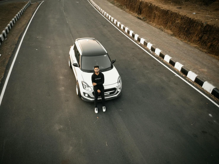 a man sitting on the hood of a white car, pexels contest winner, jayison devadas, haval f 7, centered full body shot, black road