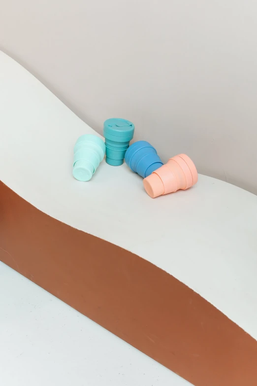 a couple of toothbrushes sitting on top of a bed, colored milk tea, terracotta, made out of plastic, detailed shot legs-up