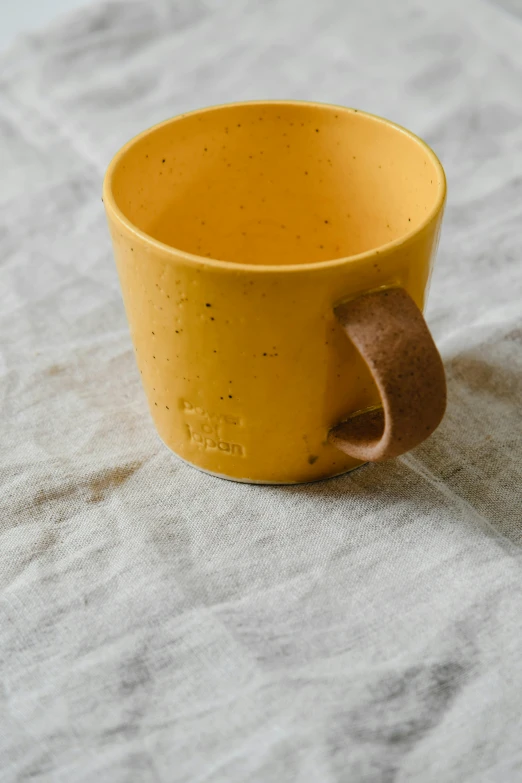 a close up of a cup on a table, inspired by Jakob Emanuel Handmann, unsplash, yellow ochre, volcanic, medium wide front shot, kids