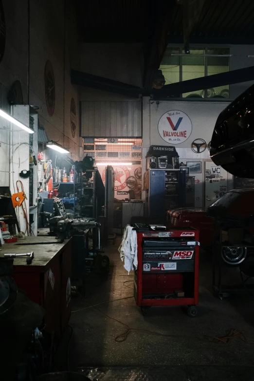 a man working on a motorcycle in a garage, a picture, unsplash, assemblage, inside of a car, sao paulo, nighttime!, uncanny valley