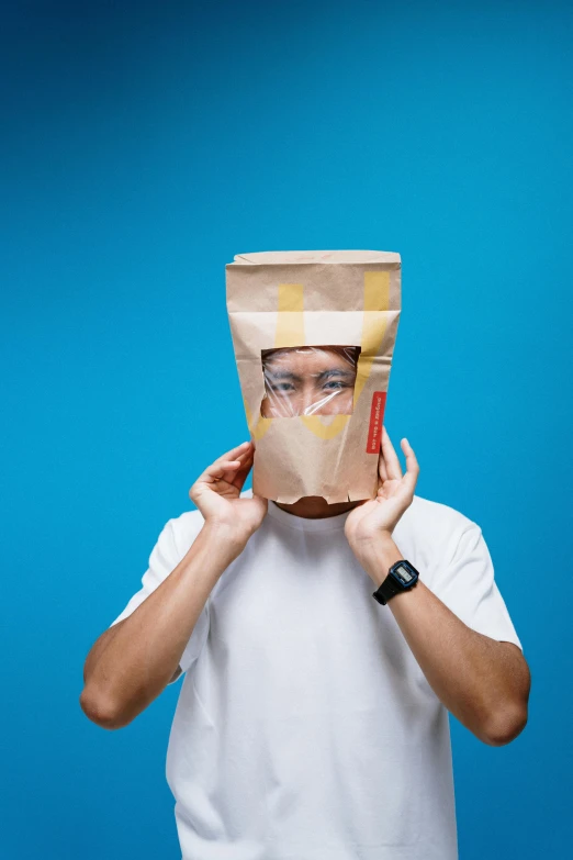 a man with a paper bag on his head, inspired by Rene Magritte, pexels contest winner, robotic face, asian male, square face, deep fried