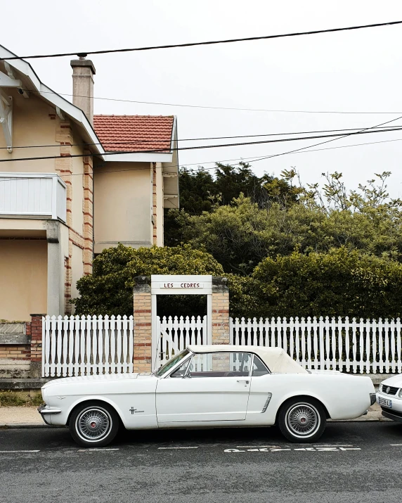 two cars parked next to each other in front of a house, an album cover, by Lee Loughridge, unsplash contest winner, mustang, north melbourne street, joel meyerowitz, seaside victorian building