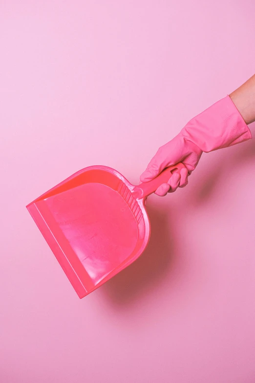 a woman's hand holding a pink dustpan against a pink background, by Julia Pishtar, pexels contest winner, plasticien, made of lab tissue, cmyk, instagram picture, poop