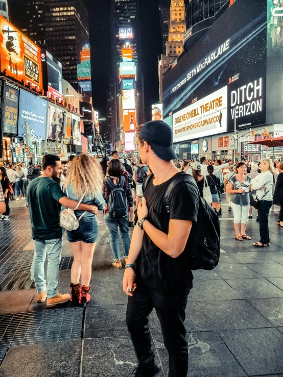 a man standing in the middle of a crowded street, standing in time square, profile image, sports photo