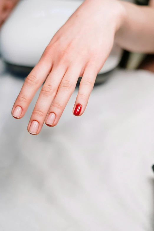 a close up of a person's hand with a red manicure, subtle colors, with pointing finger, ultradetailled