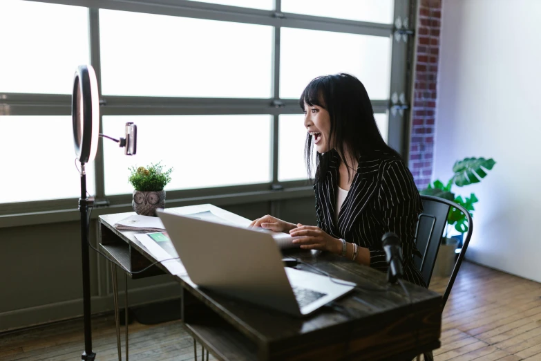 a woman sitting at a desk using a laptop computer, pexels contest winner, laughing hysterically, asian female, gif, professional photo