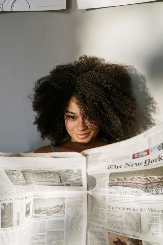 a woman holding a newspaper in front of her face, a cartoon, trending on unsplash, long afro hair, great light, new york times, a black man with long curly hair