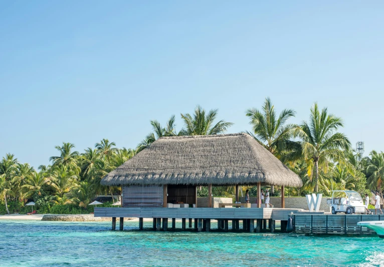 a thatched hut sitting on top of a body of water, reefs, three michelin star, exterior photo, sunny day time