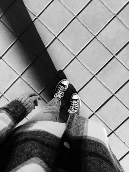 a person standing on a tiled floor with their feet on a skateboard, inspired by Vivian Maier, shot with iphone 1 0, high contrast!!, sneaker photo, winter vibes