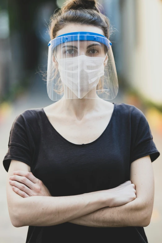 a woman wearing a face shield with her arms crossed, by Adam Marczyński, people, wide, market, closeup photograph