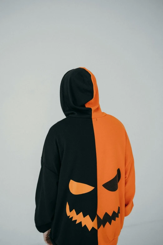 a person wearing an orange and black halloween hoodie, trending on pexels, yinyang shaped, studio shot, split in half, product introduction photo