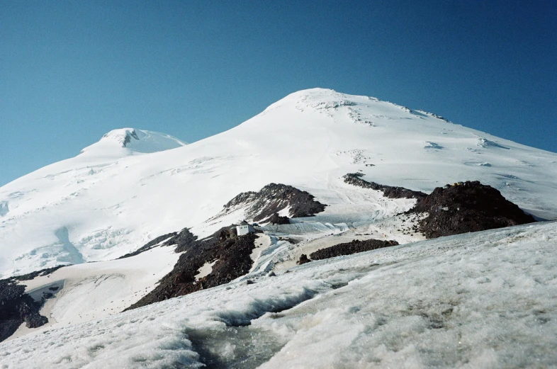 a man standing on top of a snow covered mountain, hurufiyya, seen from afar, taken on a 2000s camera, an ice volcano, 2022 photograph