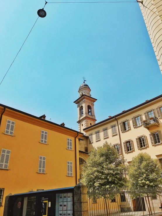 a yellow building with a clock tower in the background, inspired by Raffeaello Ossola, renaissance, lead - covered spire, abbondio stazio, photo taken in 2 0 2 0, brown ) )