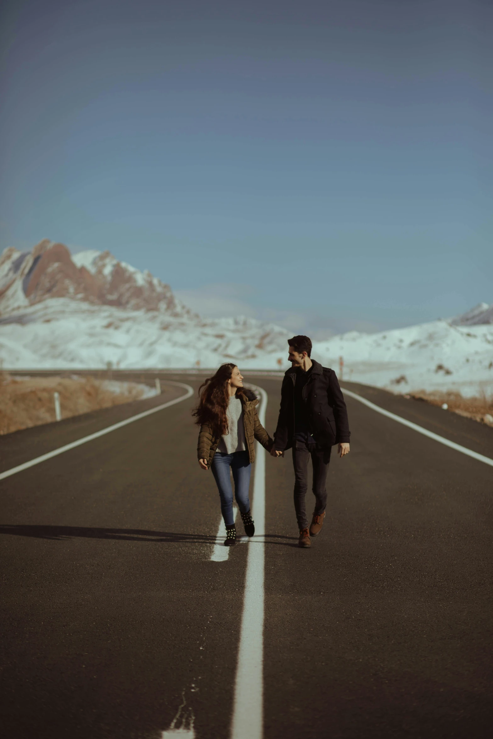 a couple walking down a road holding hands, pexels contest winner, romanticism, icy mountains in the background, reza afshar, handsome man, background image