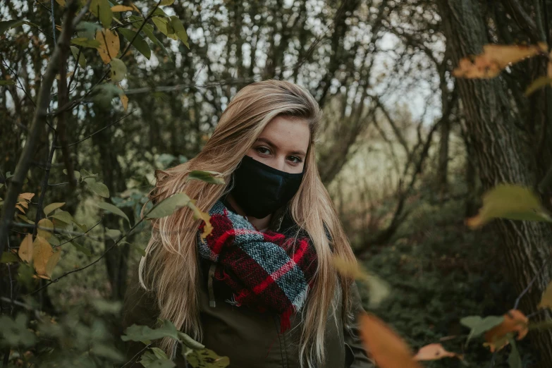 a woman wearing a face mask in the woods, by Emma Andijewska, trending on pexels, black scarf, a blond, in a post apocalyptic setting, college