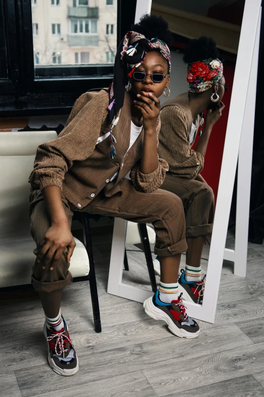 a woman sitting on a chair in front of a mirror, by Jeka Kemp, trending on pexels, afrofuturism, focus on sneakers only, portrait androgynous girl, brown clothes, 3 / 4 pose