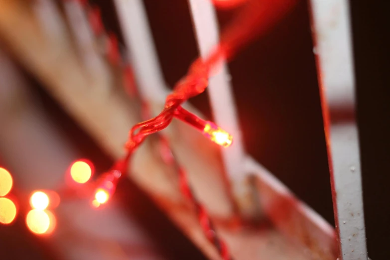 a close up of a string of lights, red wires wrap around, blood red, extra detail, led lighting effects