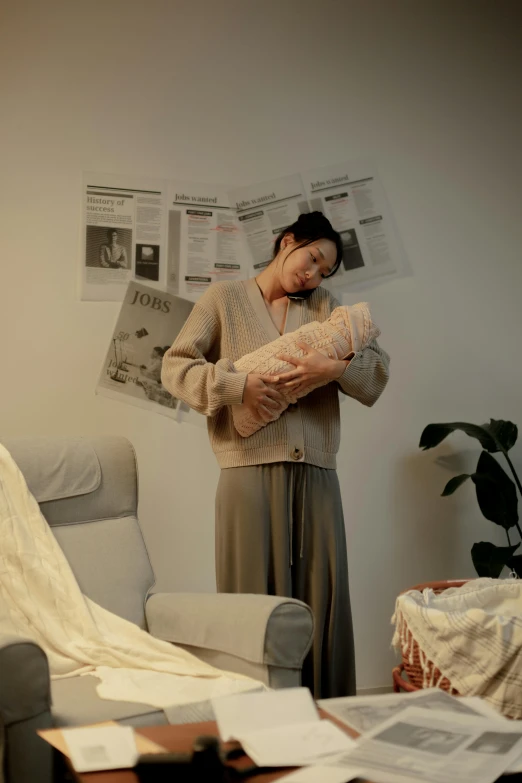 a woman holding a baby in her arms, by Jang Seung-eop, unsplash, realism, in a japanese apartment, real life size, ignant, realistic footage