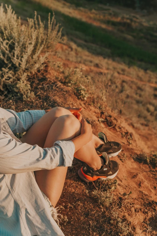 a woman sitting on the side of a dirt road, trending on pexels, sneaker photo, grand canyon | golden hour, flat lay, snacks