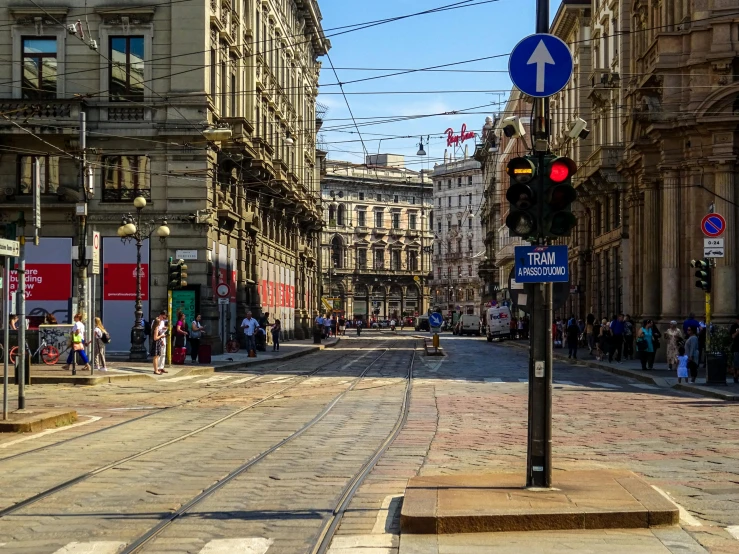 a street filled with lots of traffic next to tall buildings, by Carlo Martini, pexels contest winner, renaissance, milan schere, on a great neoclassical square, wires hanging above street, on a sunny day