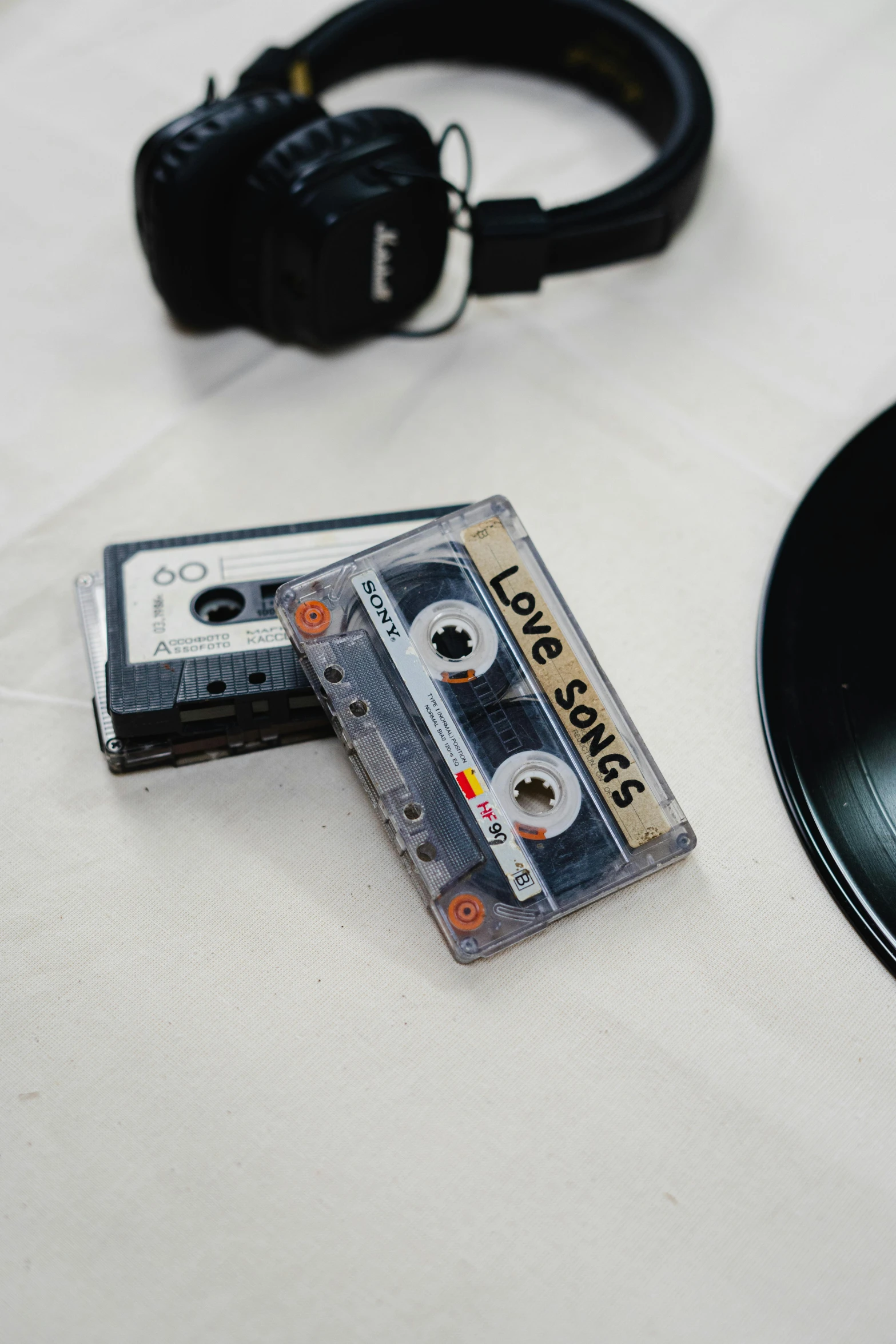 a couple of cassettes sitting on top of a table, on a white table, love os begin of all, behind the scenes, 40mm tape