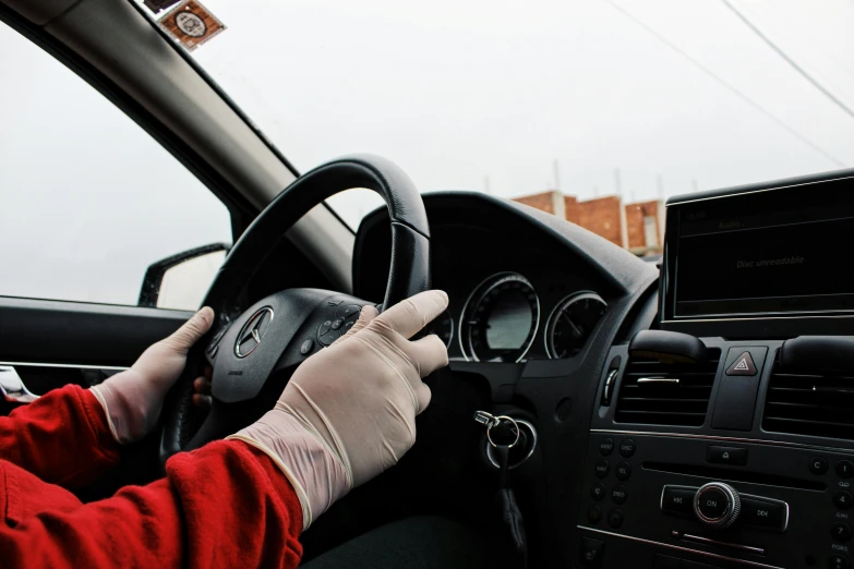 a person in a red jacket driving a car, wearing gloves, bandage on arms, 15081959 21121991 01012000 4k, instagram post