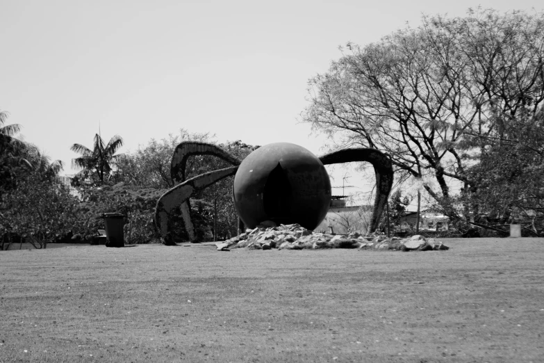 a large metal object sitting in the middle of a field, an abstract sculpture, by Alexander Stirling Calder, an atom bomb explosion in mumbai, bw photo, giant crab, rounded architecture